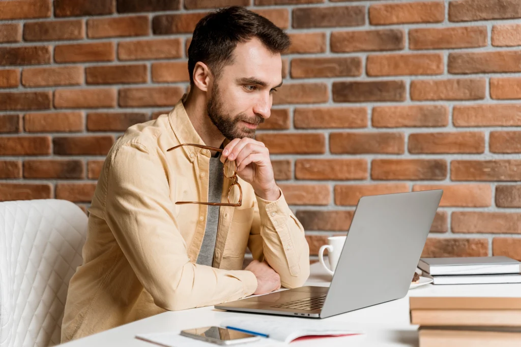 Focused businessman working on laptop at home office desk