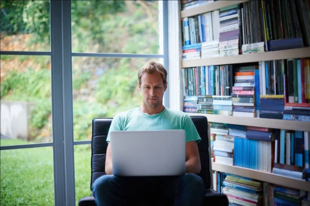 Man working on laptop in home library