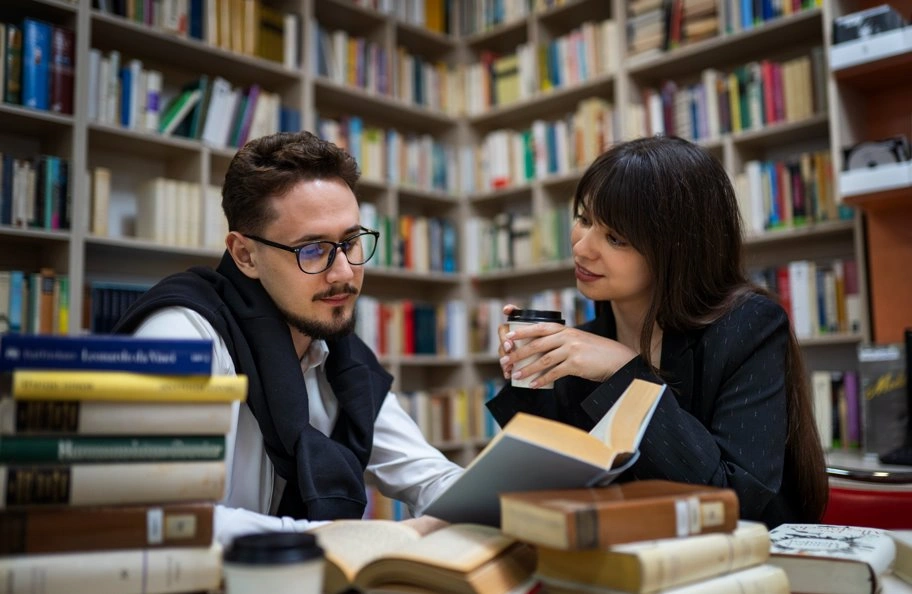 students studying together in library with open books
